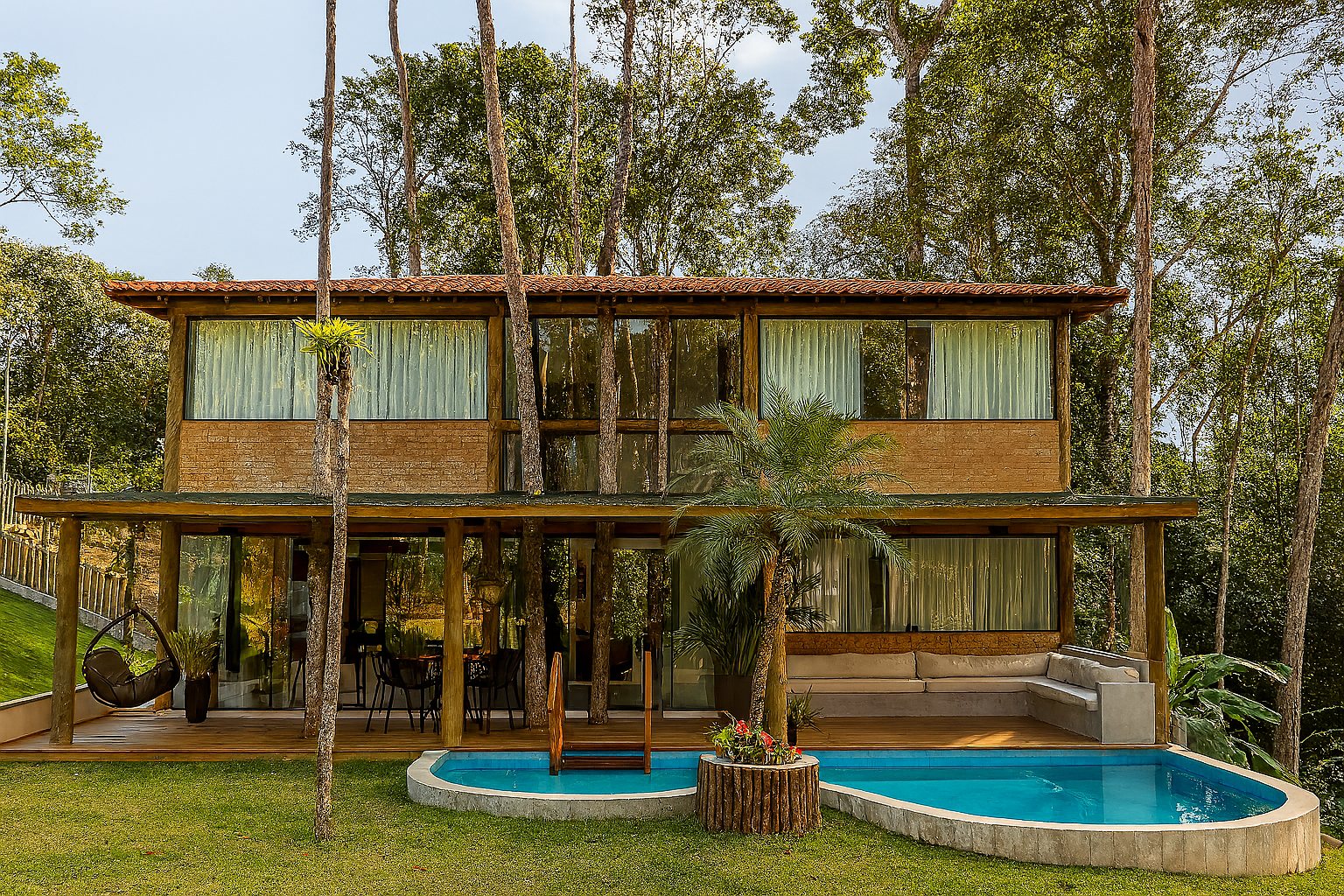 Fachada da Casa Bem Bahia cercada pela Mata Atlântica e em frente à piscina
